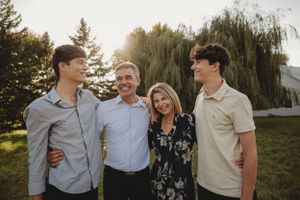 Small group portrait against willow tree backdrop during sunset.