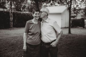 Black and white portrait of couple sharing intimate moment outdoors.