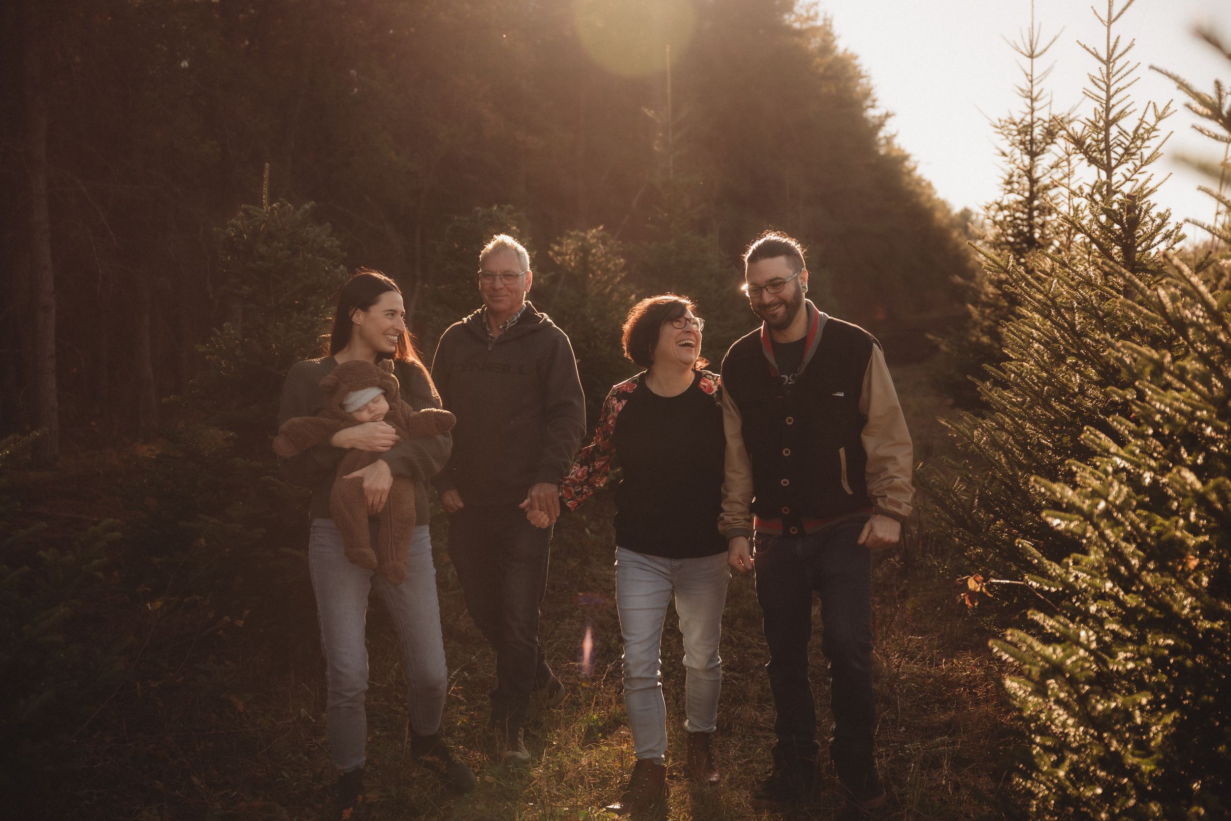 Group enjoying an outdoor walk together in a pine forest during sunset.