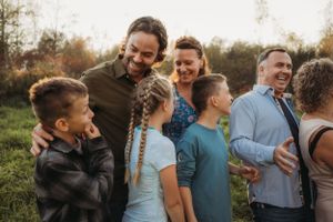 Candid moment of family members sharing laughter outdoors during golden hour.