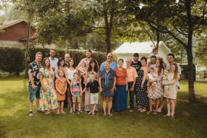 Large group gathered outdoors for casual summer celebration photo.