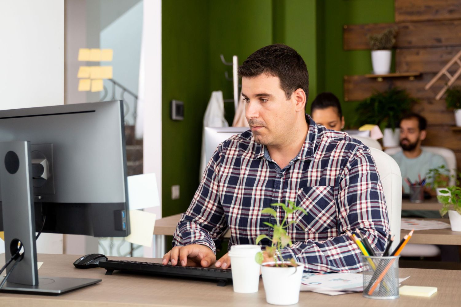 Young caucasian business man working looking serious at his computer monitor and typing