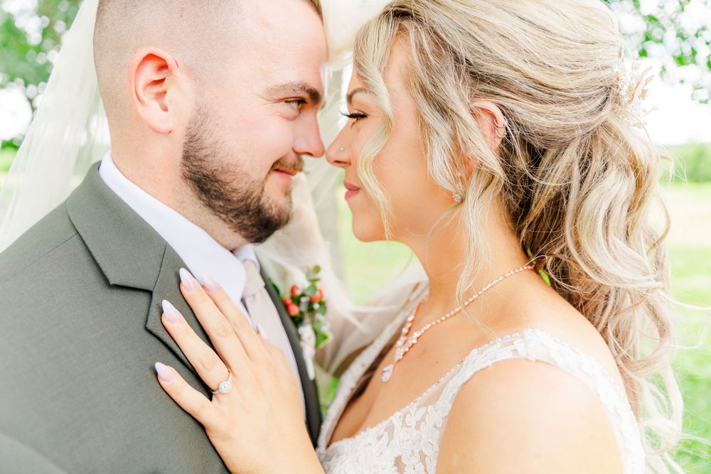 Intimate wedding portrait with couple sharing tender moment outdoors.