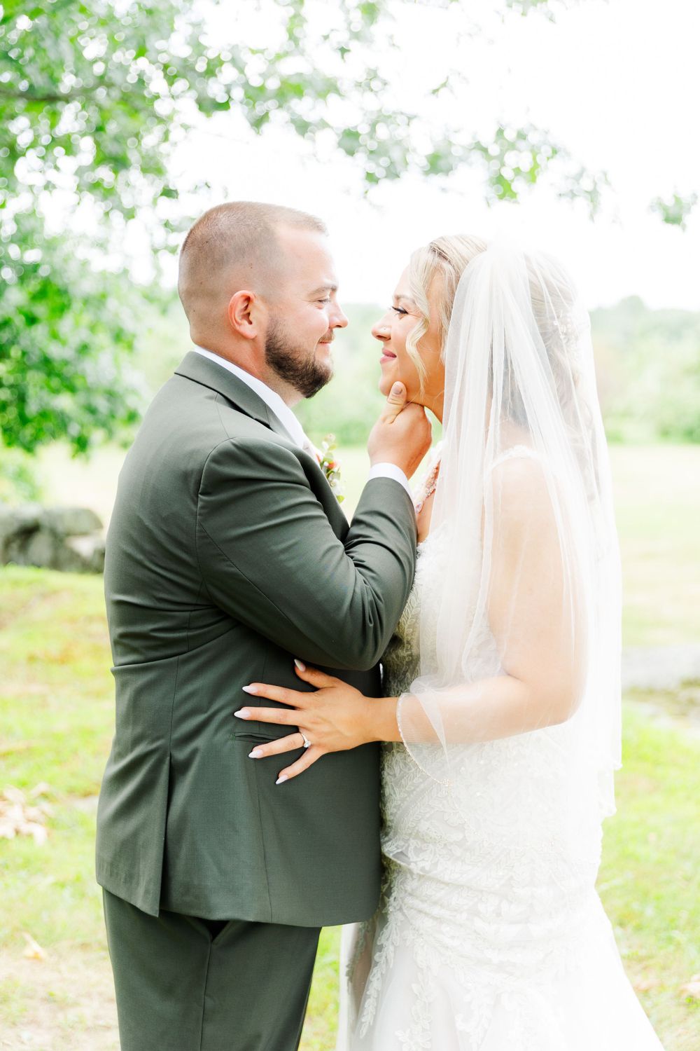Romantic outdoor wedding portrait with couple sharing intimate moment.