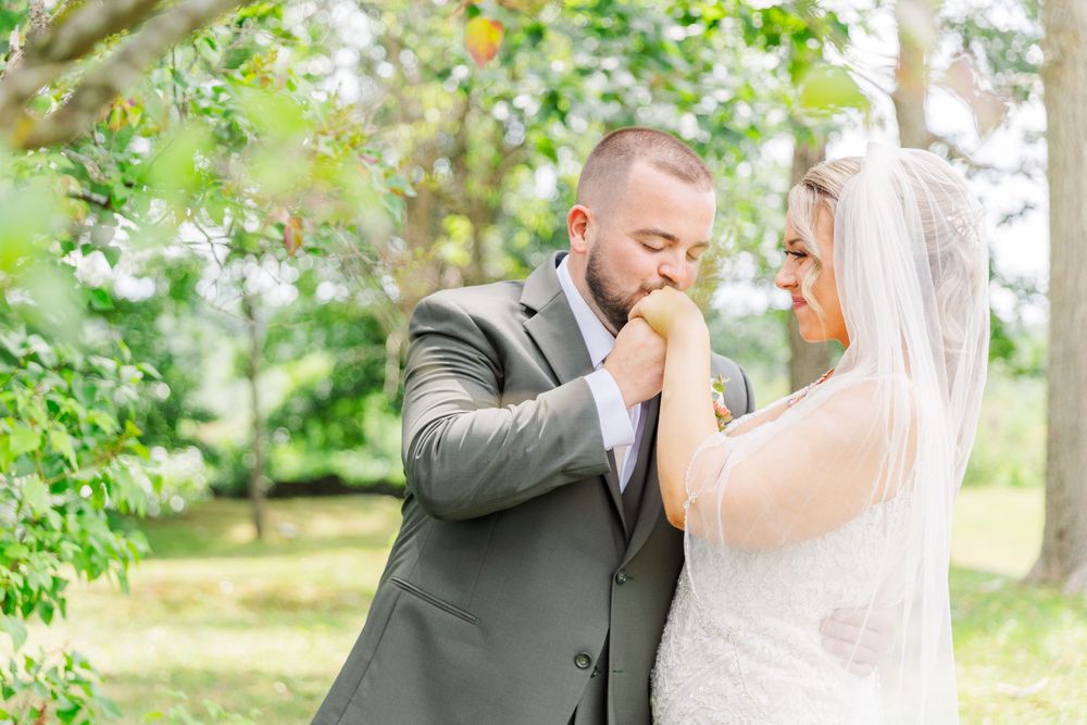 Sweet wedding moment captured in garden setting with soft natural light.