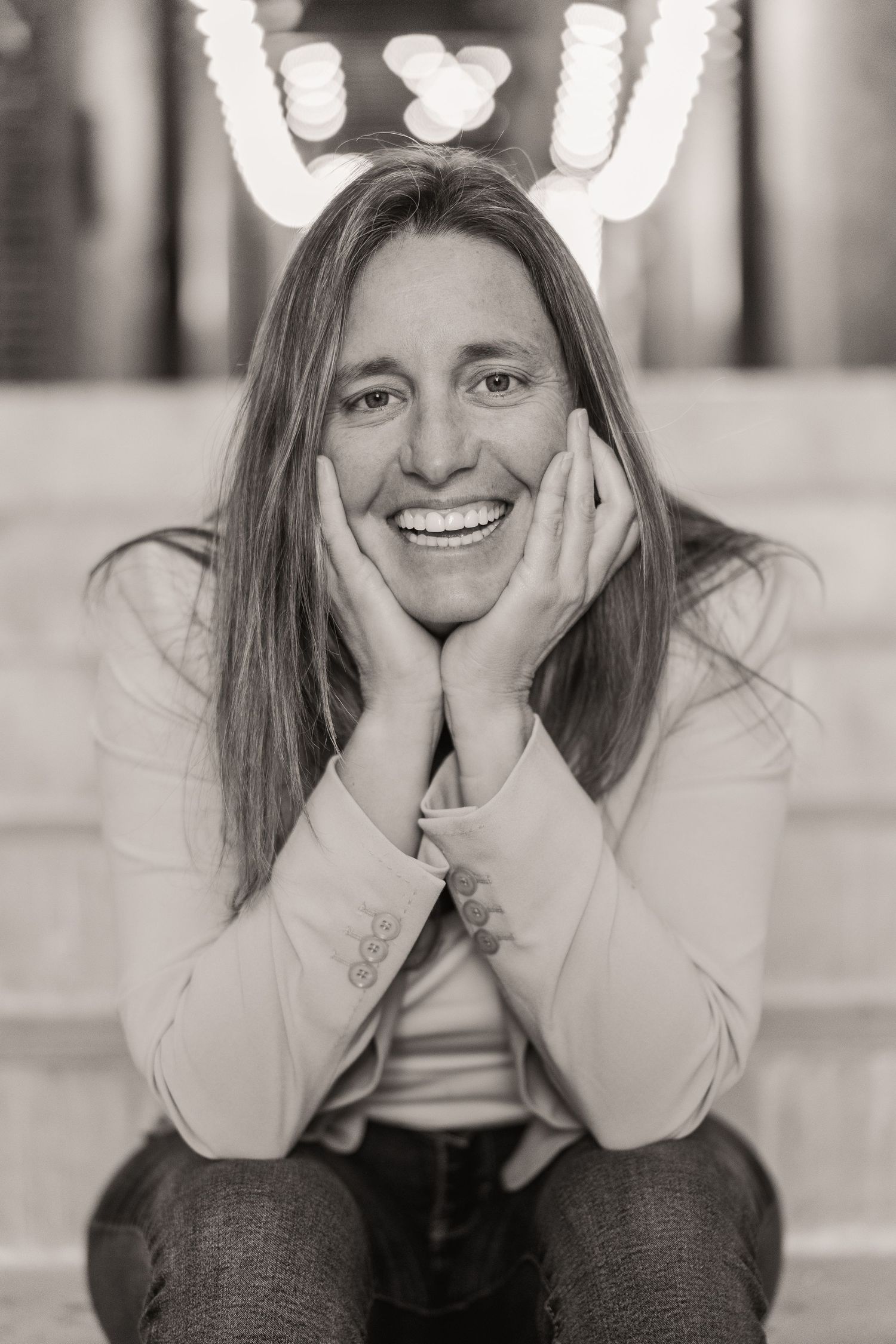 Black and white portrait of woman in her 40s with a serious gaze and strong posture, creating a timeless mood.