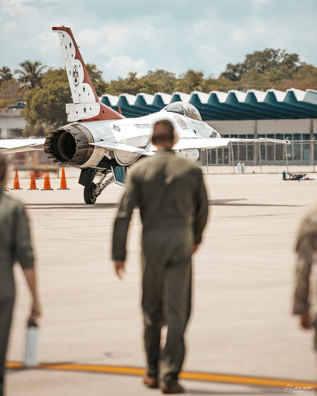 A Thunderbirds F-16 fighter jet on display with spectators viewing from the tarmac.