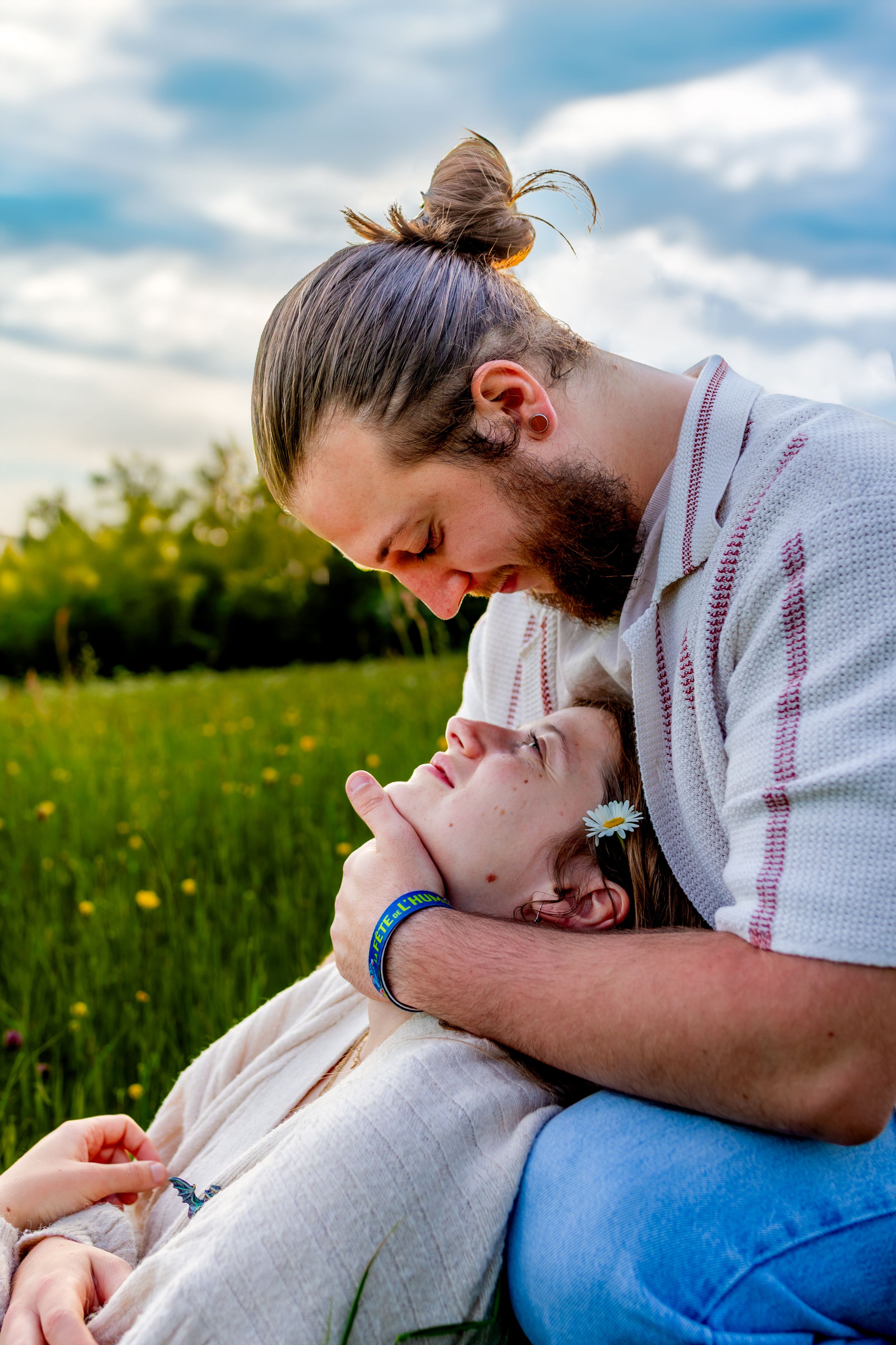 Couple assis dans l’herbe, riant ensemble – ambiance naturelle et détendue