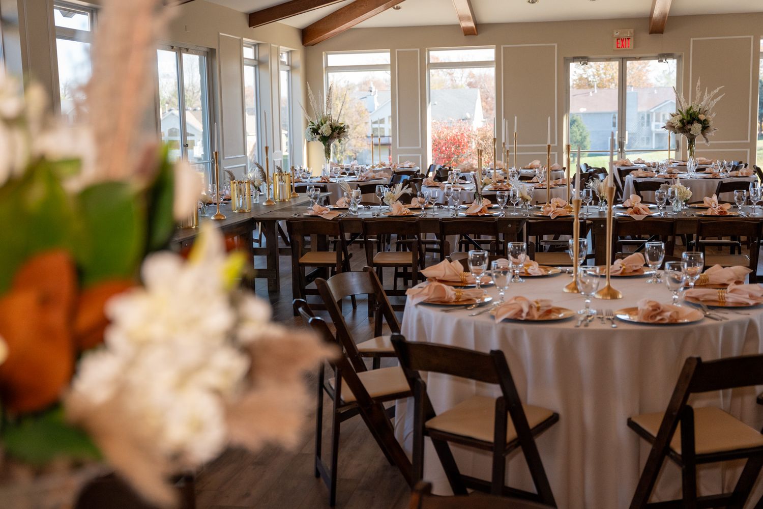 Elegant wedding reception venue with round tables and folding chairs set for dining.