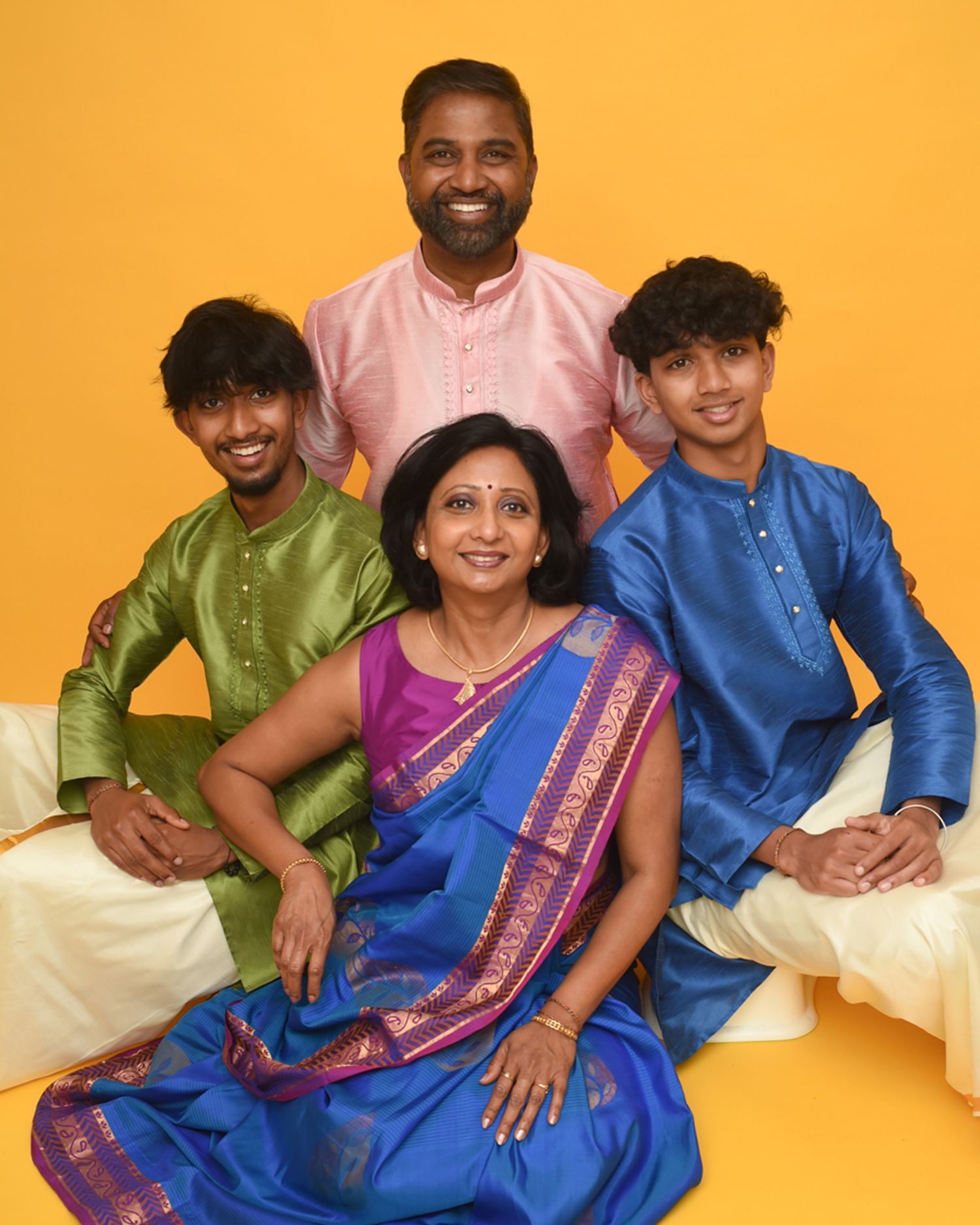 A family poses together in traditional Indian clothing, captured in a portrait by Abigail's Studio in Buckinghamshire.