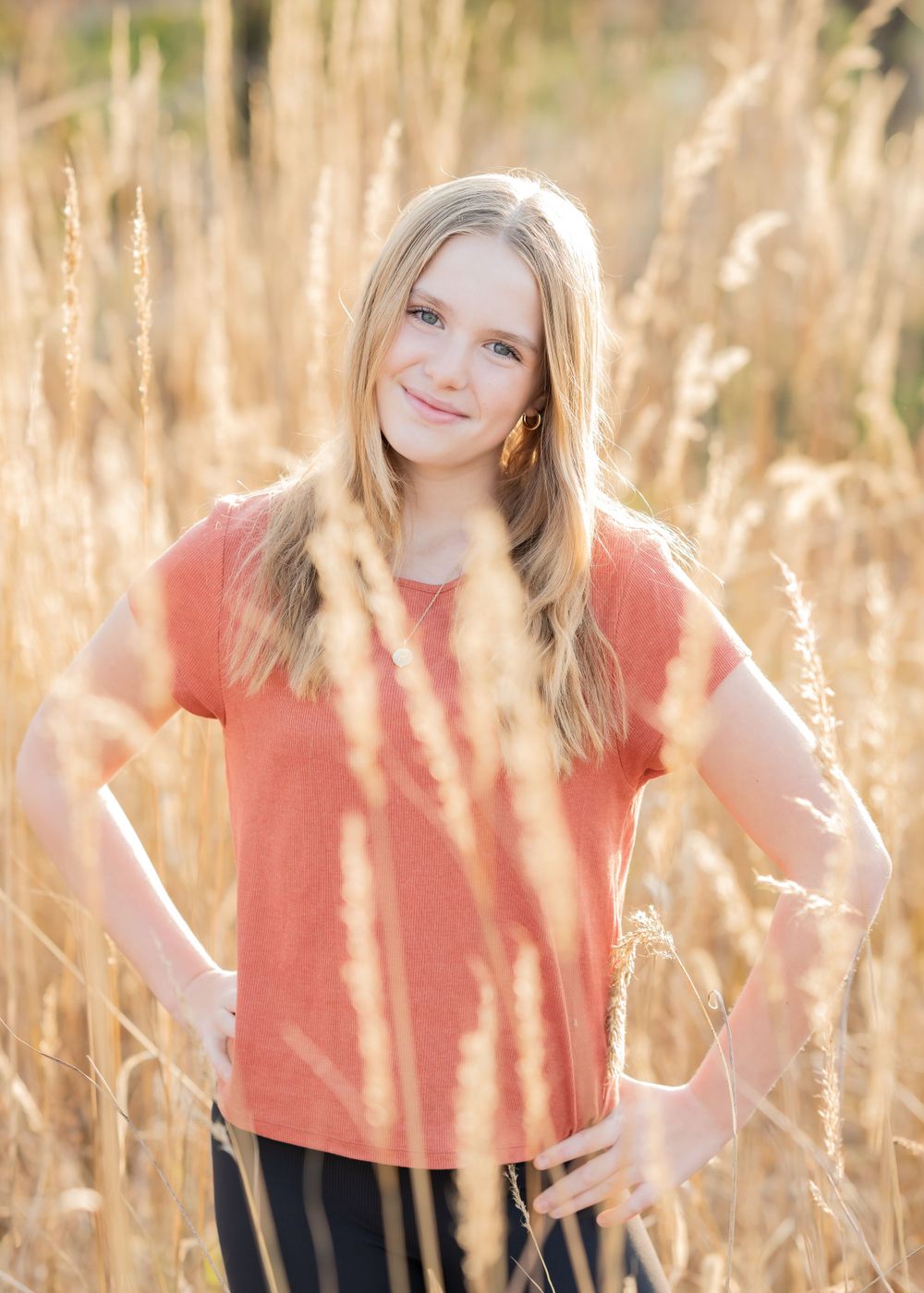 Portrait in golden wheat field with warm sunset lighting.