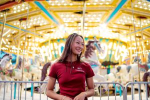 Joy and laughter at a carnival with illuminated carousel in the background.