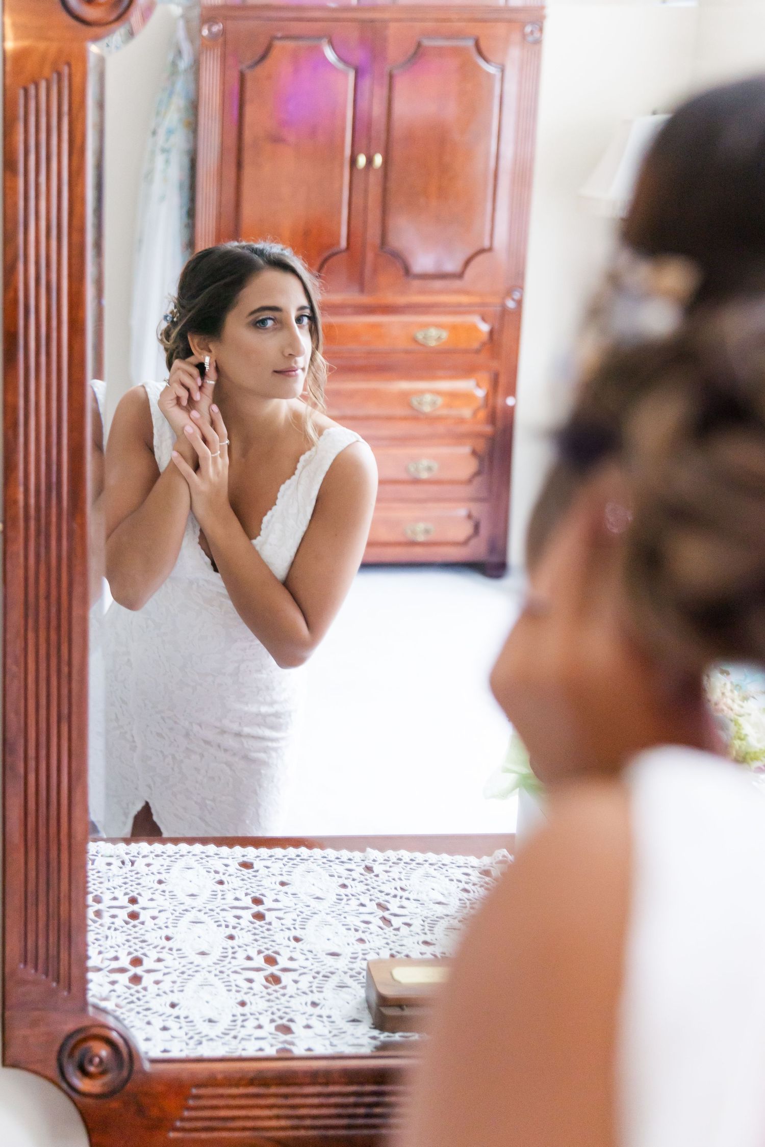 Reflection in ornate mirror showing wedding preparation moment.