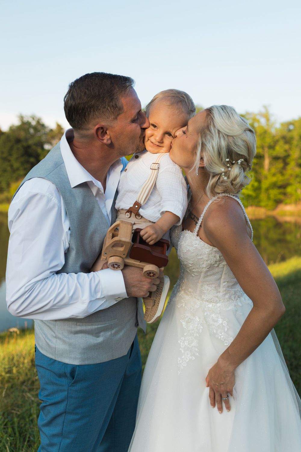 just married couple kissing their todler son