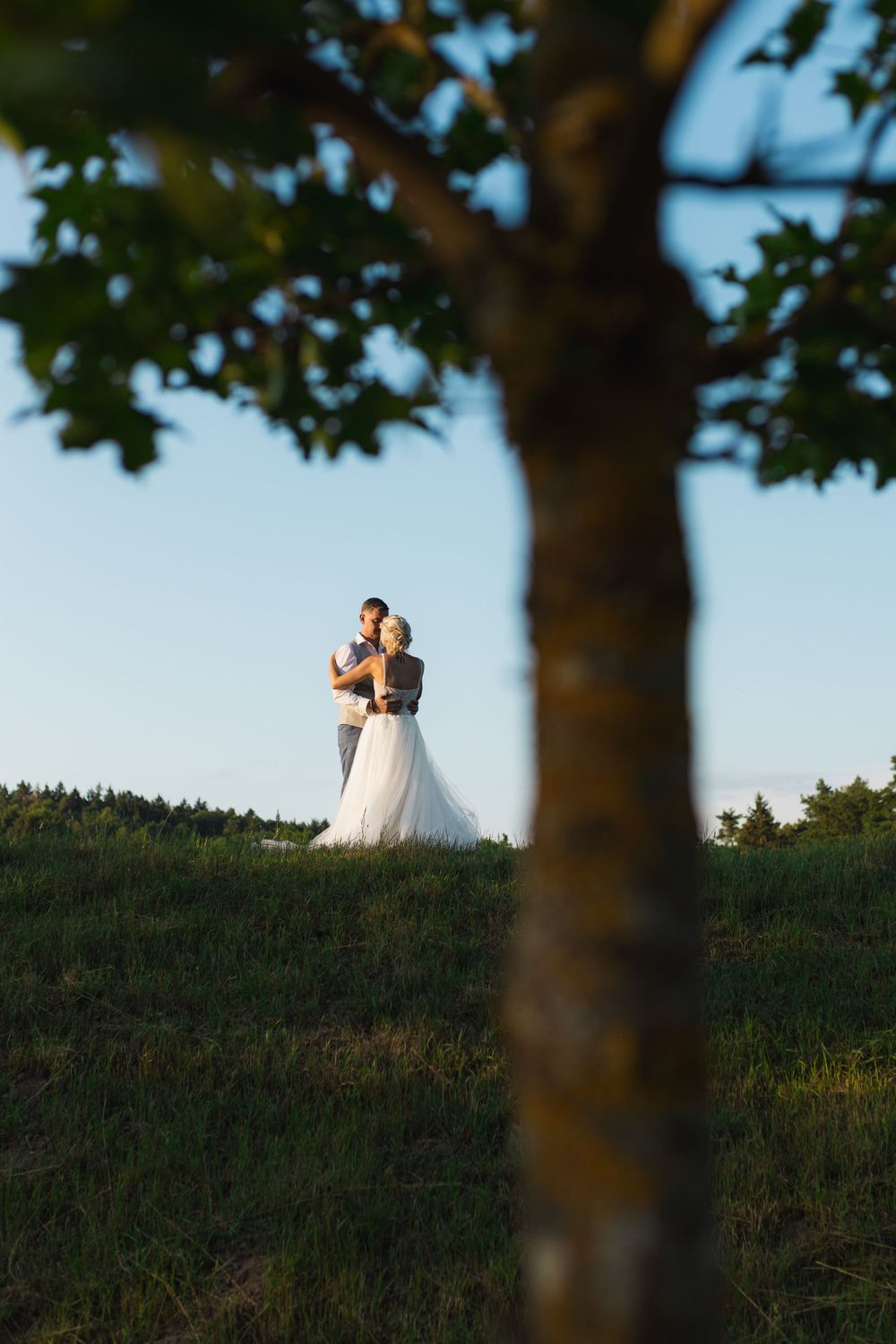 sunset photo of just married couple on a hill