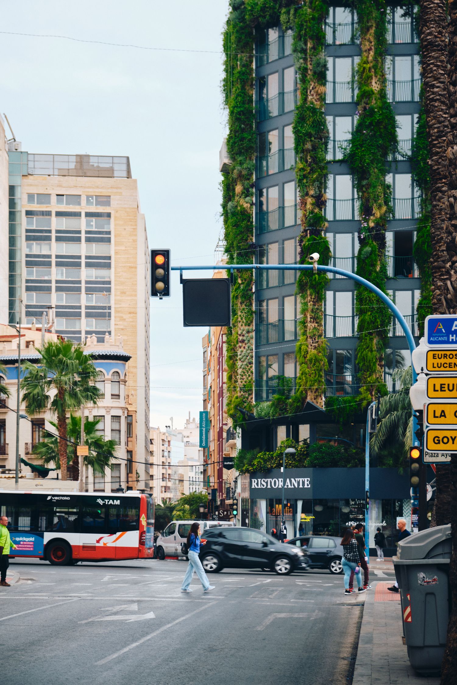 Modern building with vertical green gardens on its facade in an urban downtown setting.