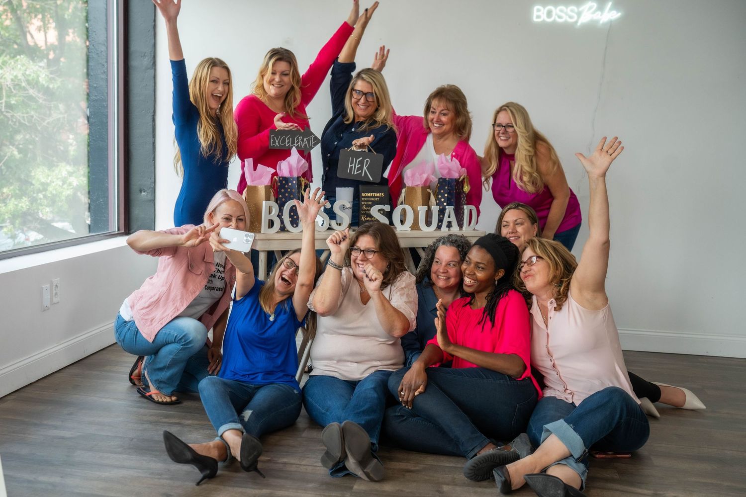 Group of women sitting on floor in casual attire during a fun photoshoot session.