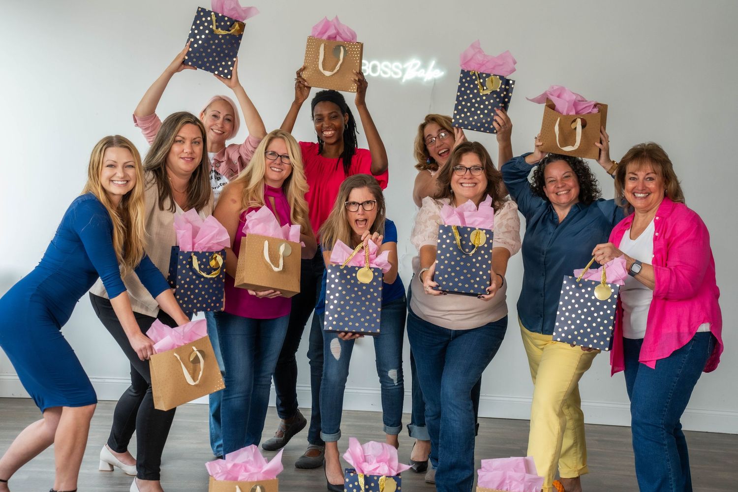 Women posing together with gift bags and decorations during a celebratory gathering.