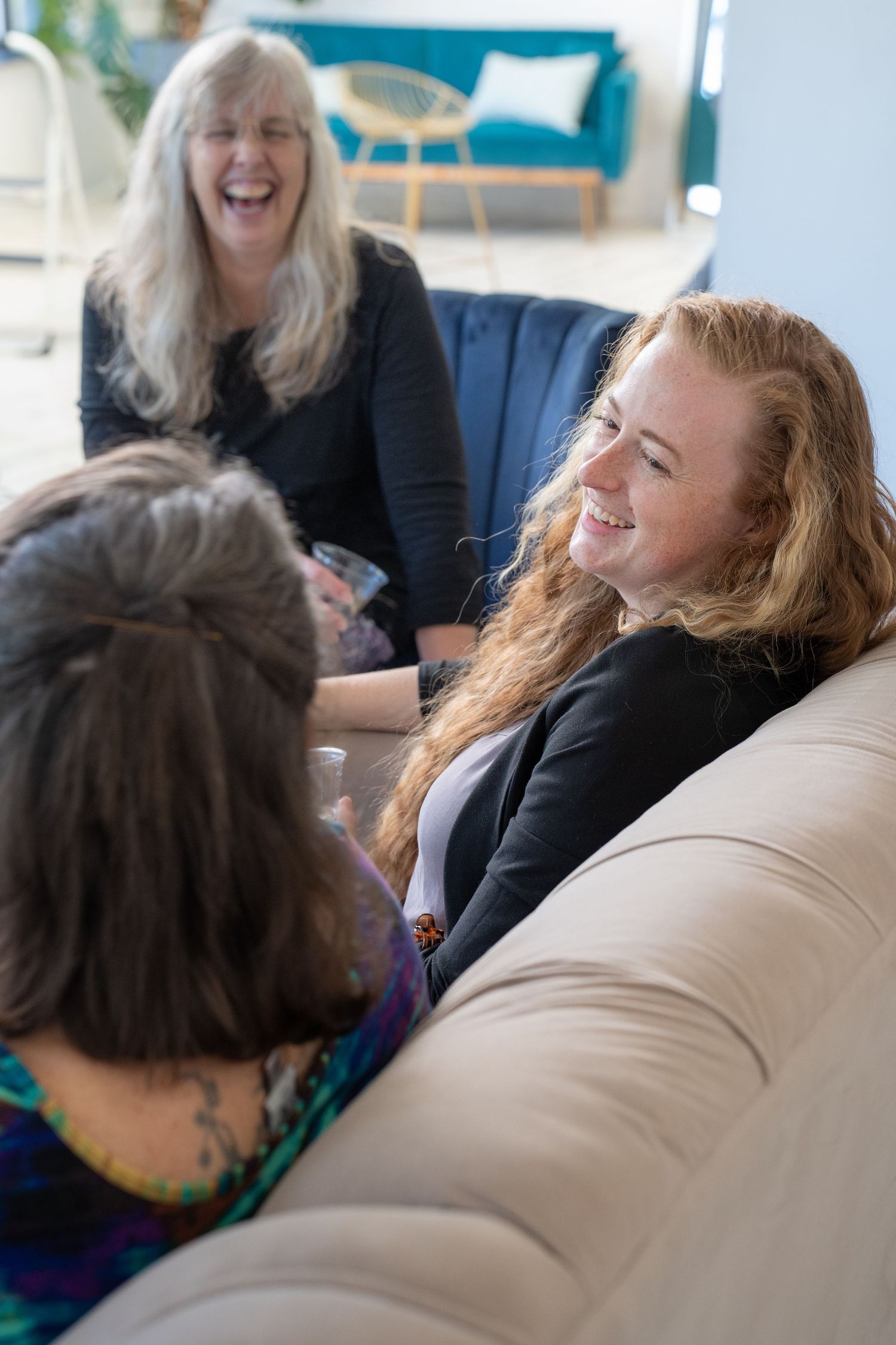 People relaxing and laughing together on a comfortable couch.