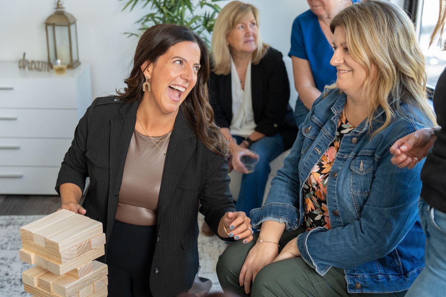 A group of people laughing and socializing together in a bright indoor space.