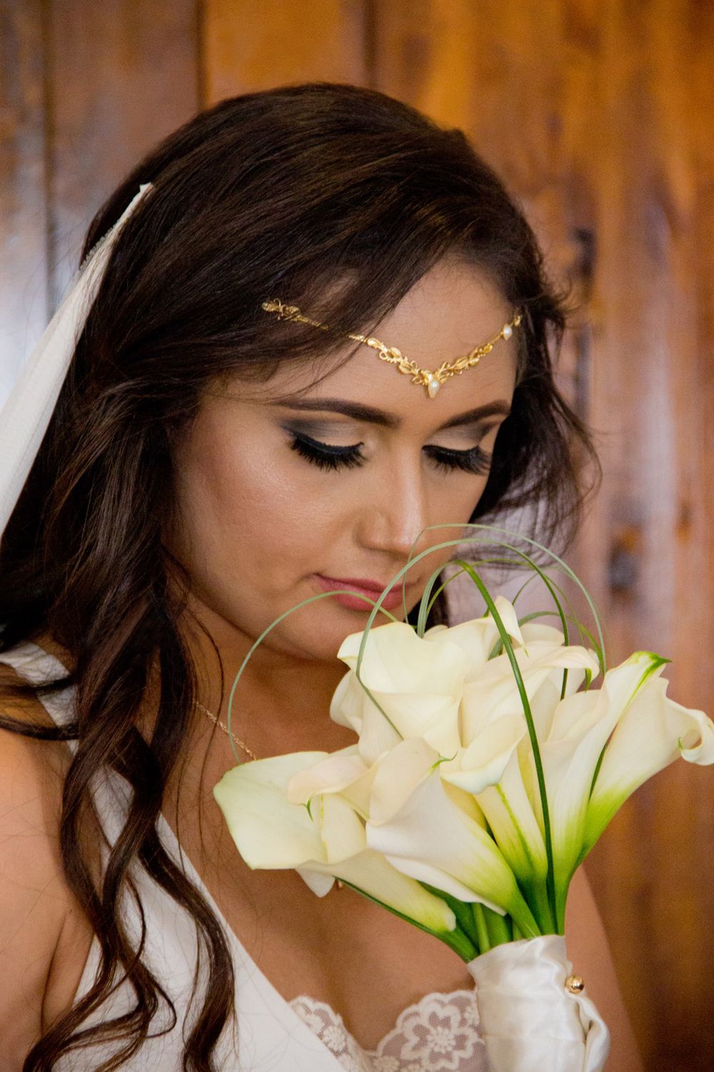 Elegant calla lily bouquet with delicate gold headpiece details in bridal portrait.
Wedding photography