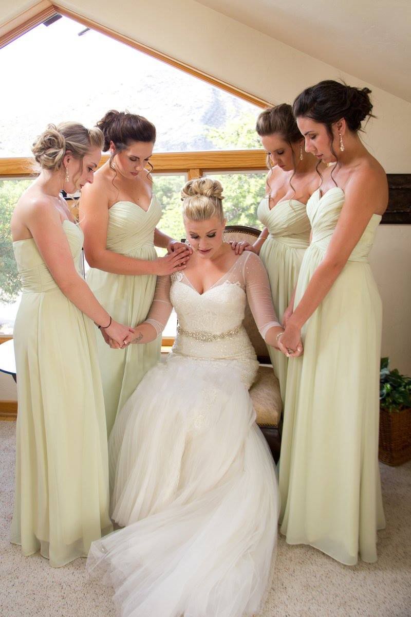Bridesmaids in dresses praying with bride before wedding.
Wedding photography