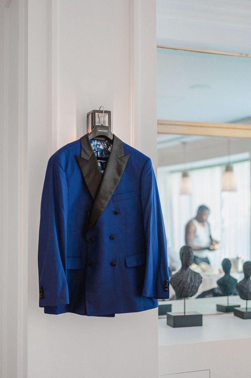 A royal blue tuxedo jacket with black lapels hanging on display.