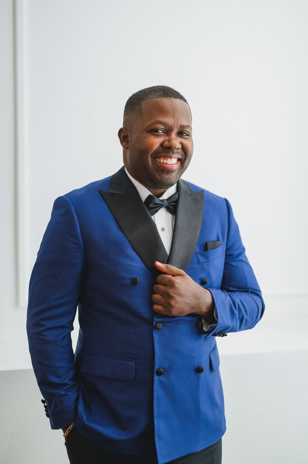 A sharp blue tuxedo jacket with black bow tie creates an elegant formal look.