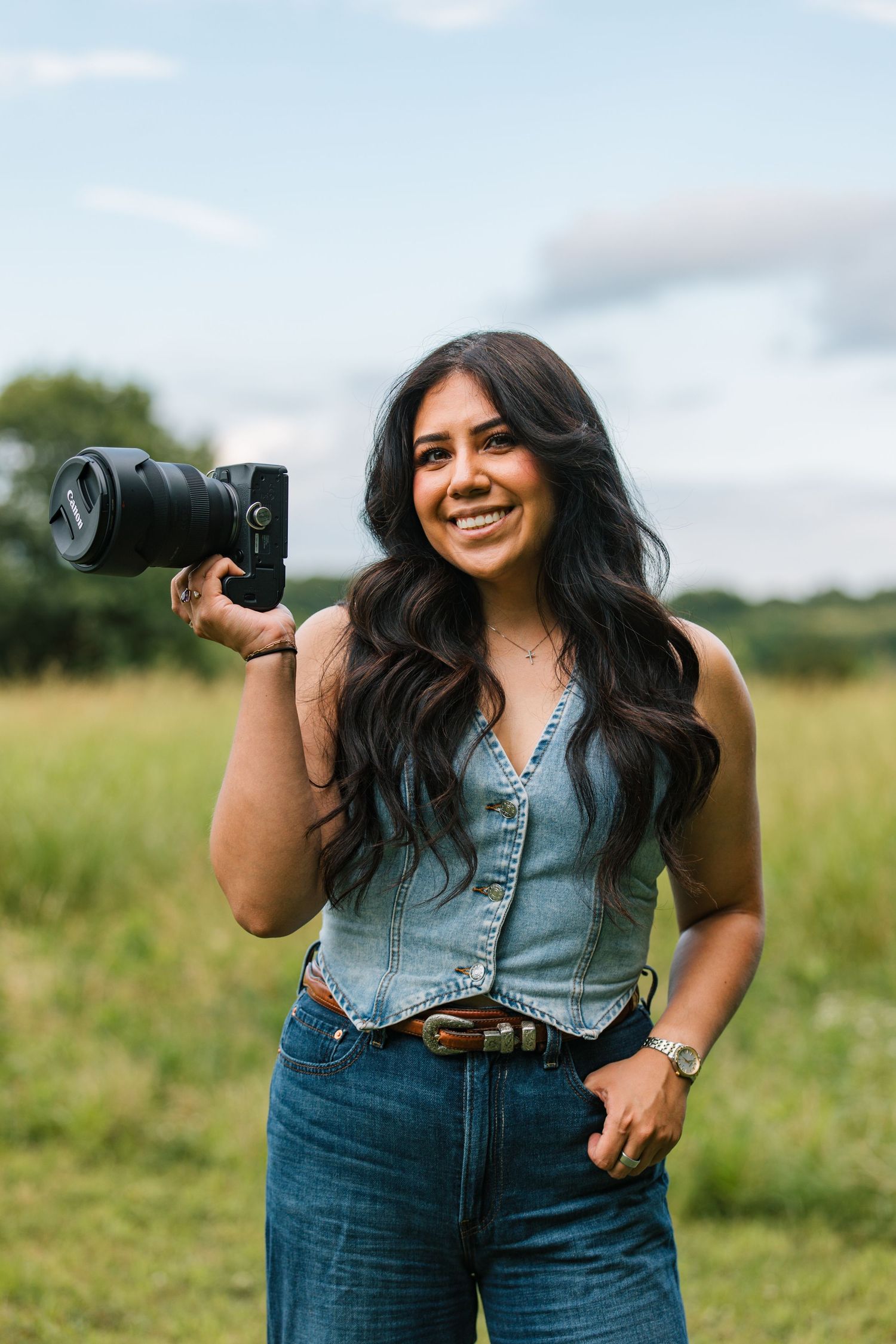 A girl poses with her Canon camera during a headshot.