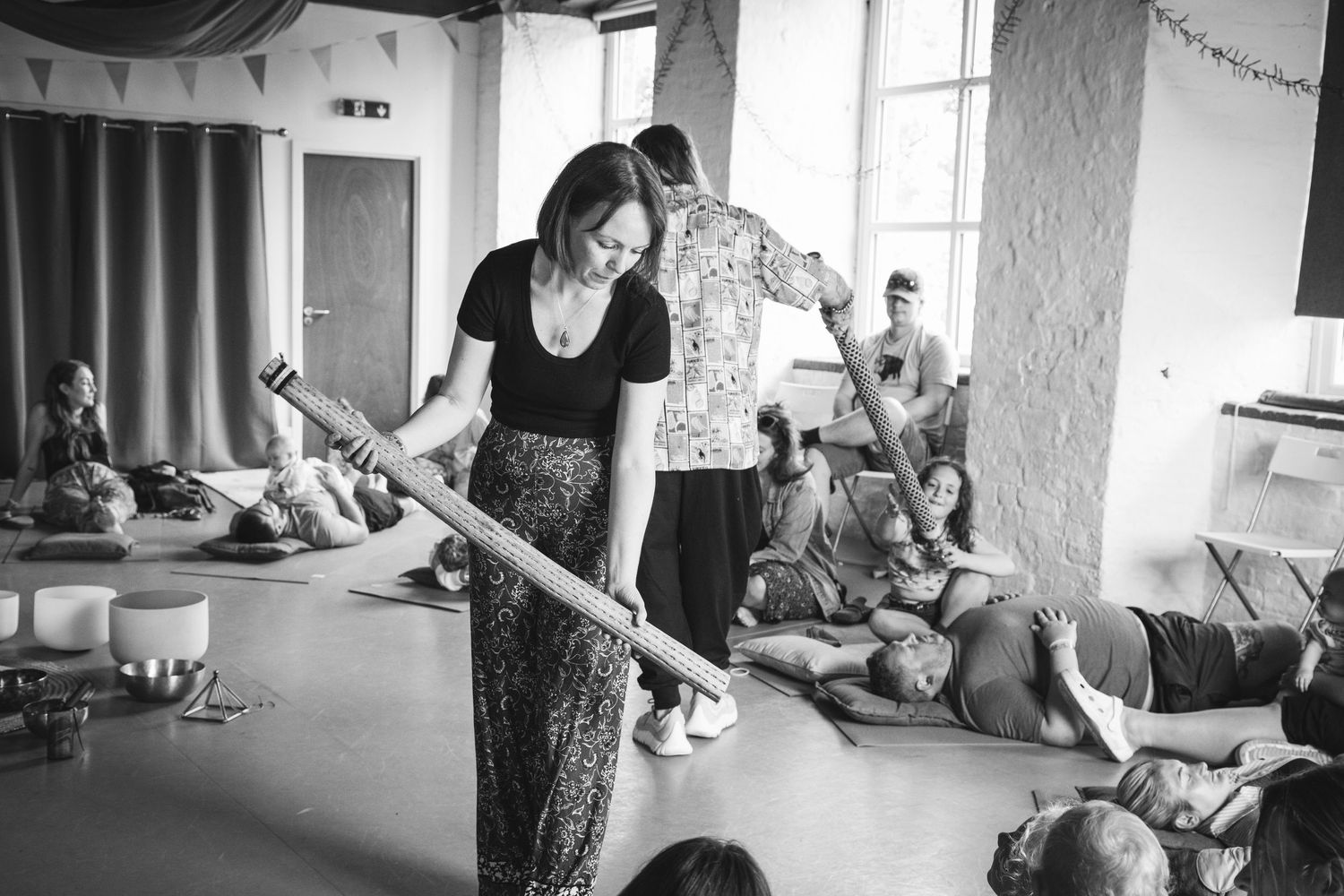 Teacher leading a group activity with children during a creative learning session in a bright classroom.