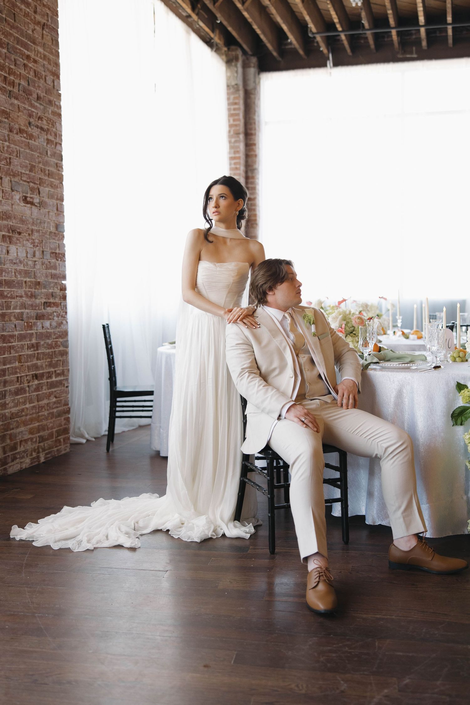 A bride in white veil leans close to groom in black suit during an intimate wedding moment.