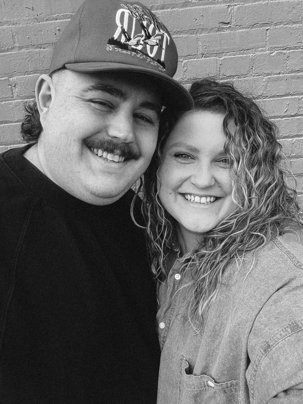 Black and white selfie of B. Logsdon and her husband smiling together.