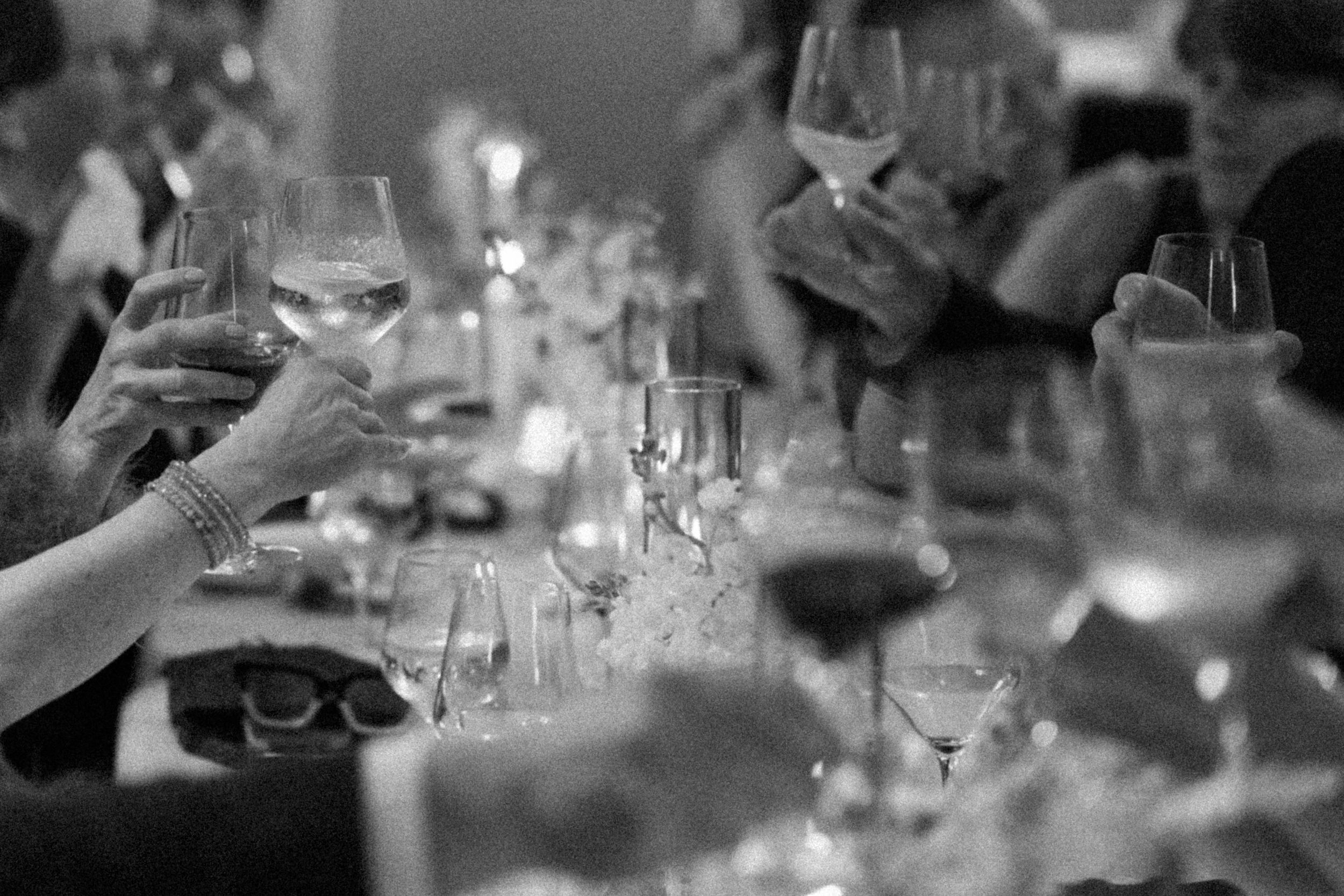 A close-up view of elegant wine glasses on a dining table with soft lighting and bokeh effects in the background.