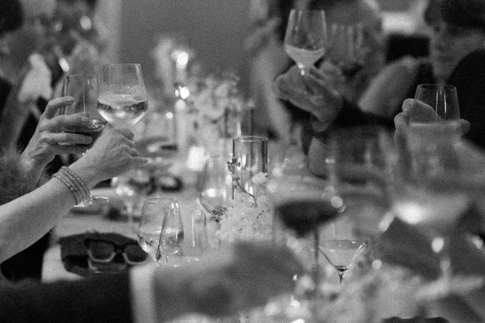 A close-up view of elegant wine glasses on a dining table with soft lighting and bokeh effects in the background.