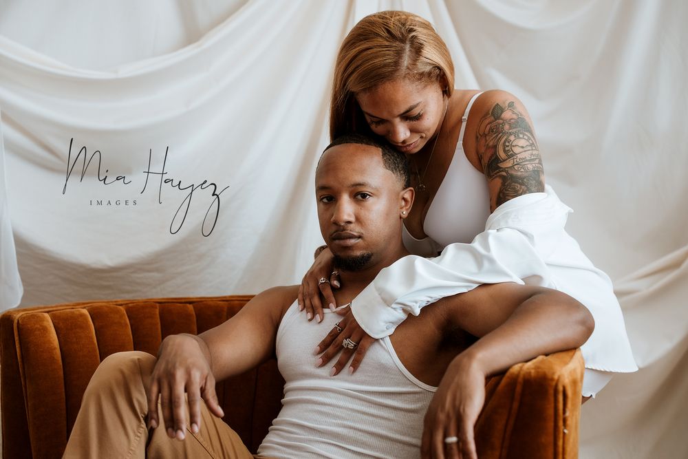 Lifestyle portrait session on a tan leather couch with white fabric backdrop.