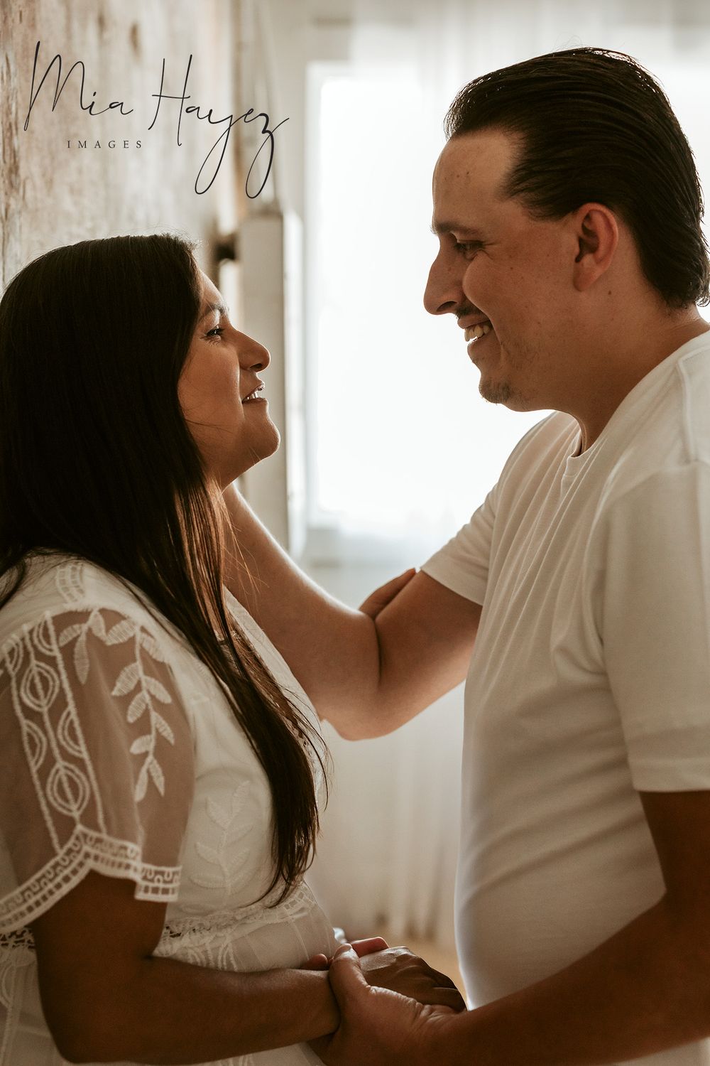 Intimate couple portrait session in white outfits with soft, natural lighting.