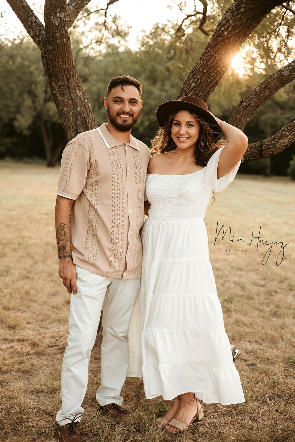 Sunset family photo session in field with golden light filtering through trees.