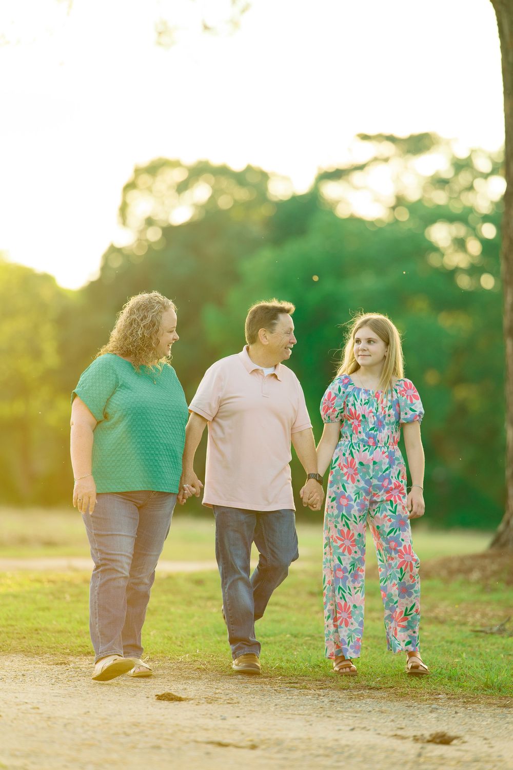 Family members walking together on a path during golden hour sunset.