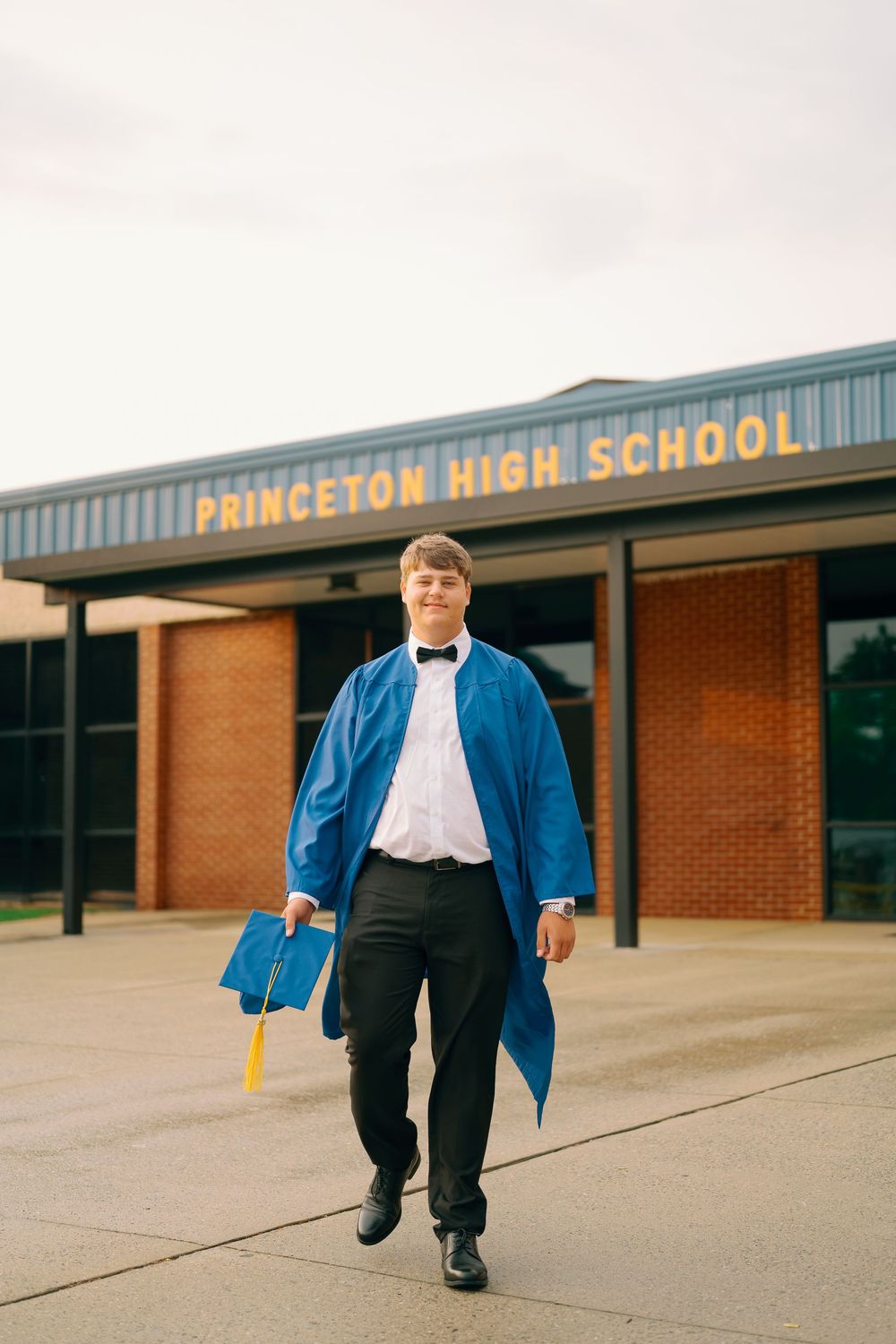 Walking shots in front of Princeton High School building with blue graduation gown.