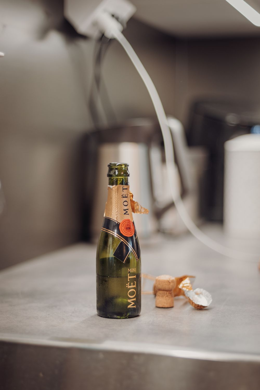 Champagne bottle and cork on a white marble surface in soft focus.