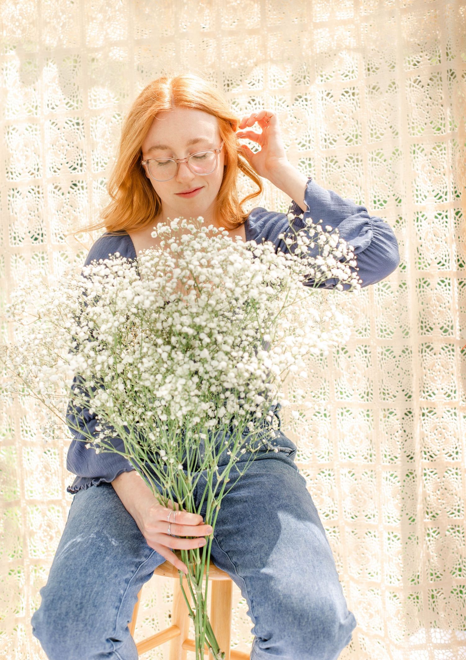 Soft portrait with delicate baby's breath bouquet against vintage lace background.