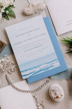 Elegant beach wedding invitation suite for Matthew Robert Ryan and Madison Victoria Love Corso with blue ocean watercolor design.