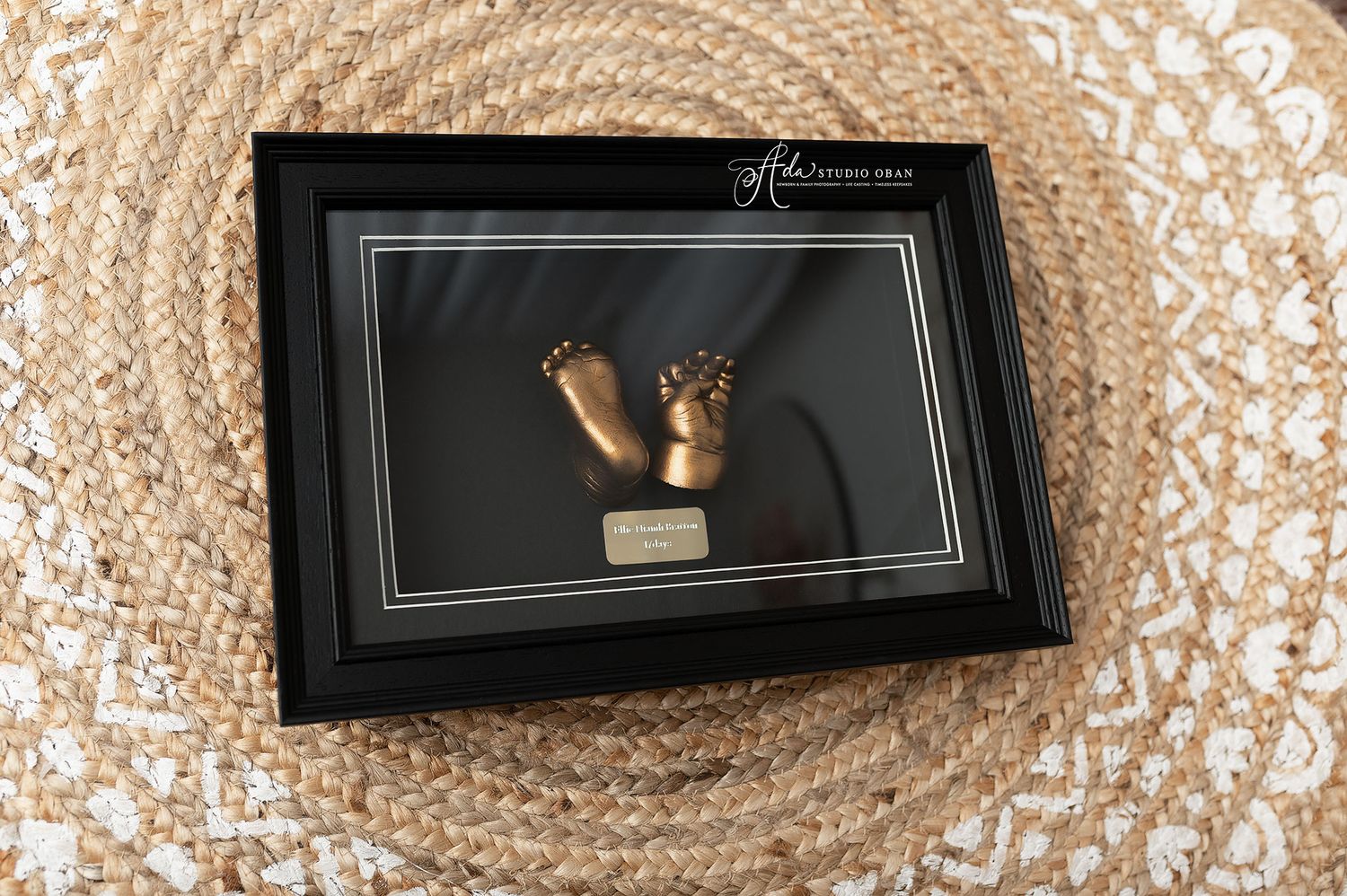 Framed 3D bronze baby feet and hands casting displayed in a black shadow box frame at Ada Studio Oban