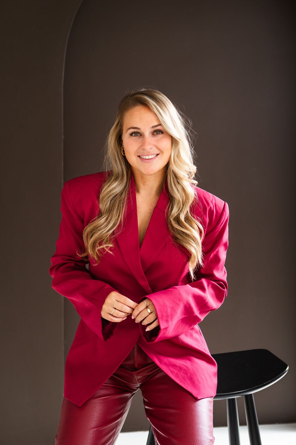 Stylish fashion photography series featuring a vibrant red blazer against a dark backdrop with modern furniture.
