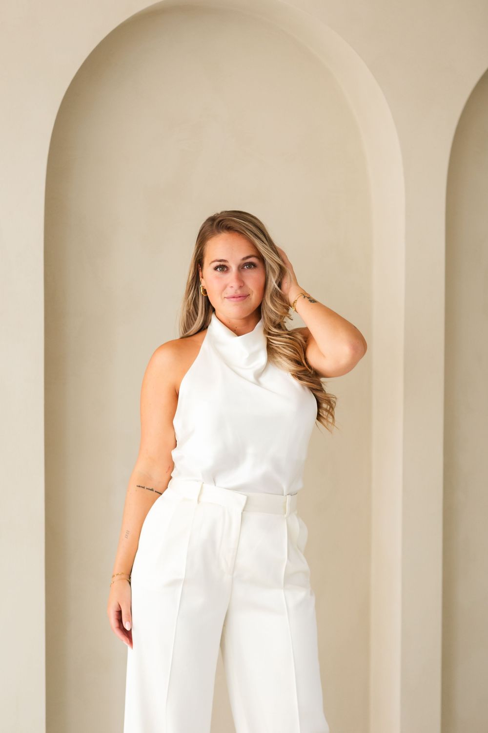 A series of fashion photos showing a white sleeveless dress against a beige wall background.