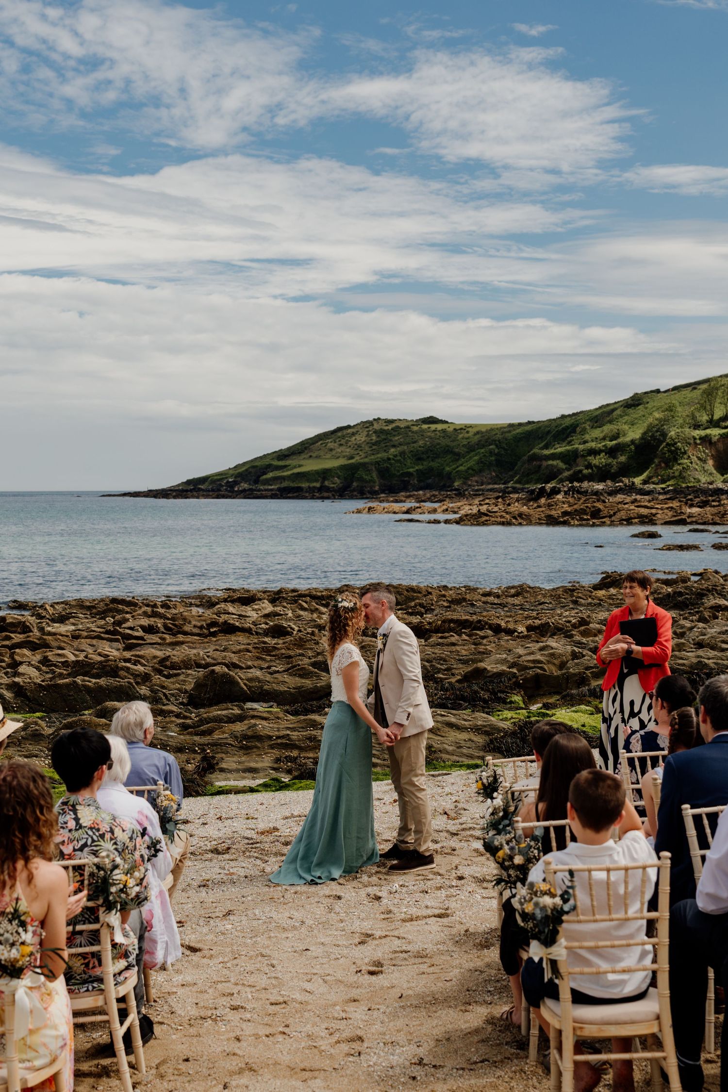 bride and groom first kiss on the beach during hotel meudon wedding ceremony.