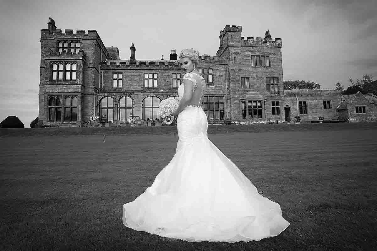 bride posses for wedding photography in front of Grade II-listed Armathwaite Hall