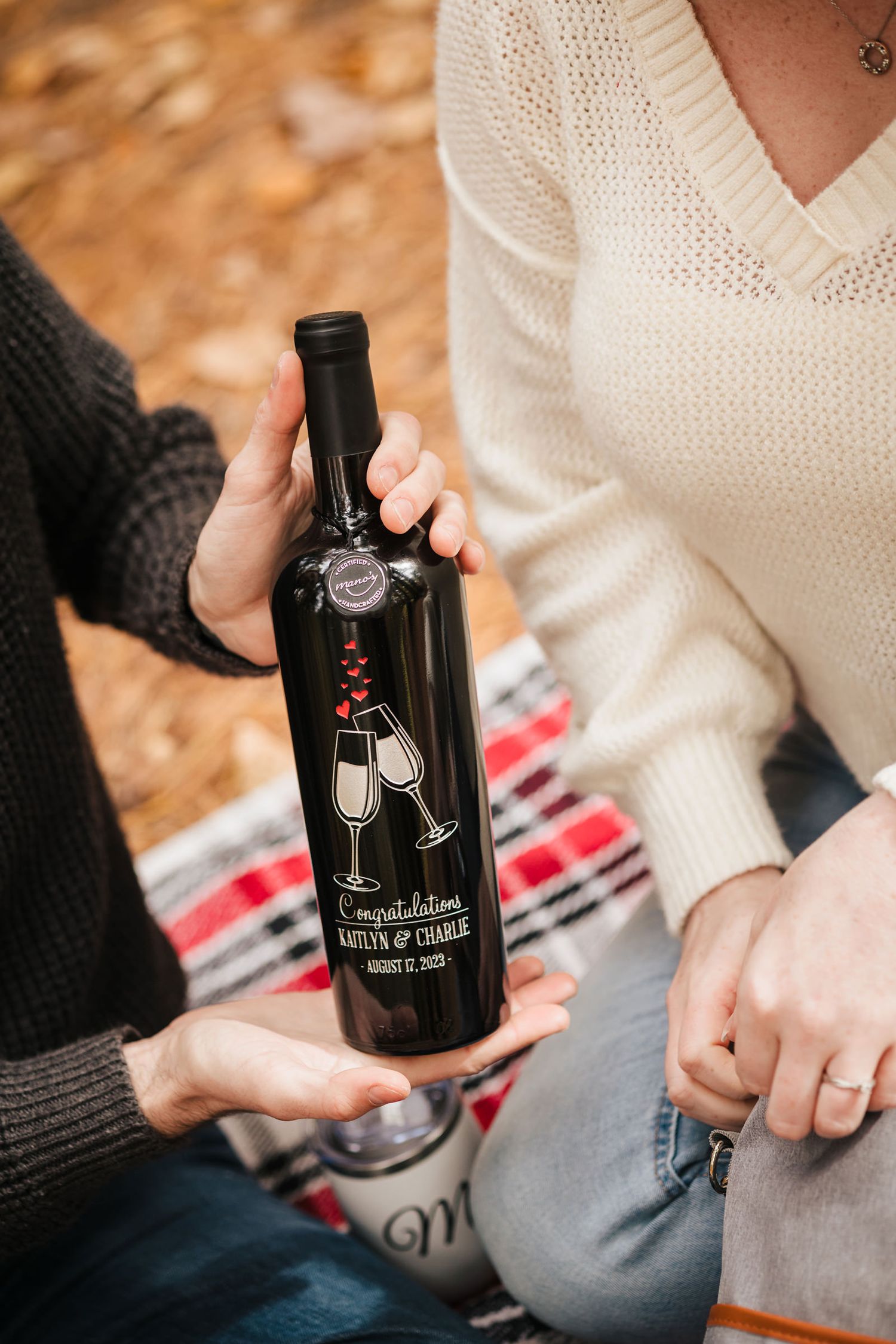 Close-up of a personalized wine bottle reading held between the couple during their picnic at Borderland State Park