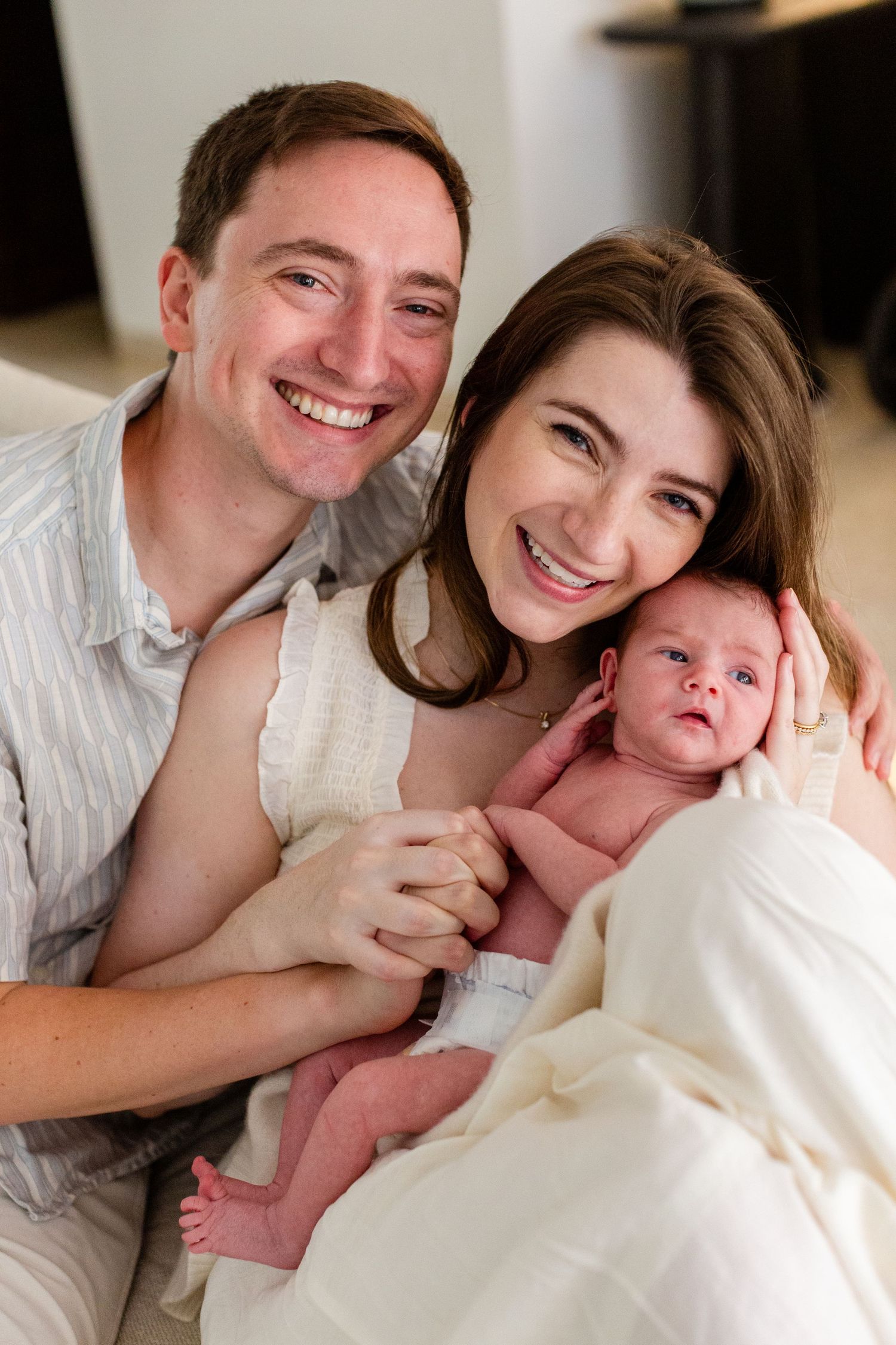 Portrait of a father, mother and newborn. In-home lifestyle newborn session in Guaynabo, Puerto Rico.