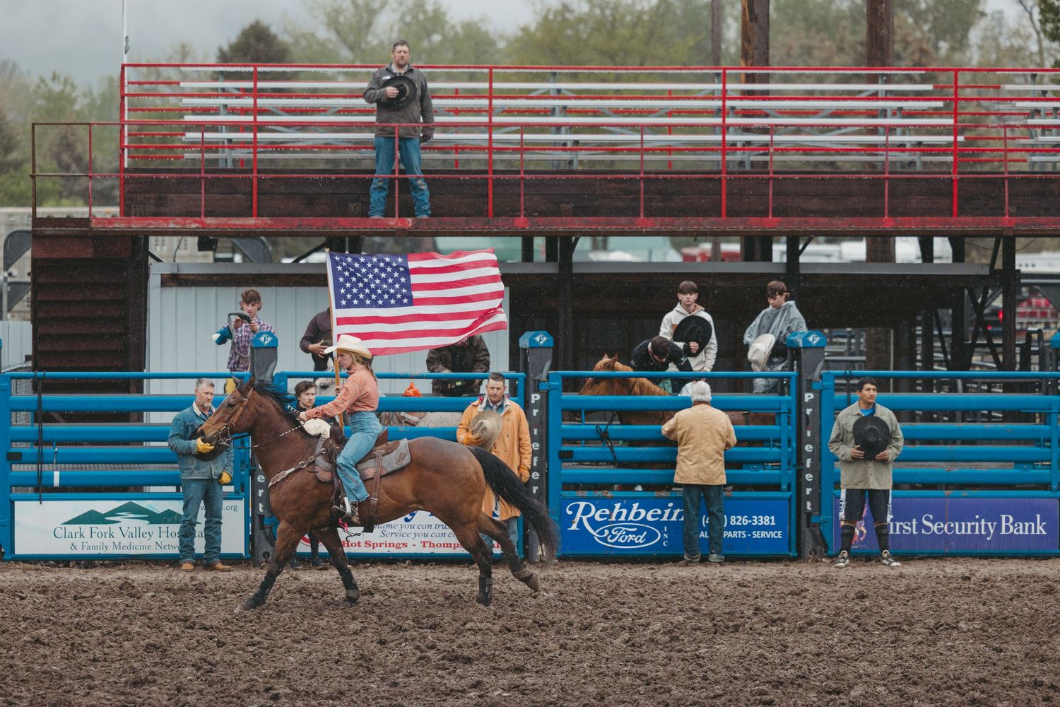 Flag girl carries American flag in Plains, MT Rodeo. Hosted by the Nothwestern Montana Rodeo Team.